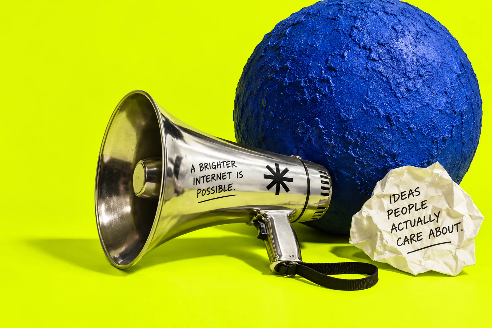 Chrome megaphone, cobalt sphere, and a paper note: Ideas people actually care about.